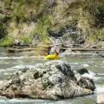 French Broad Section 9 Rafters enjoying a warm sunny day in the blue ridge mountain rafting down the French Broad in life jackets and helmets.