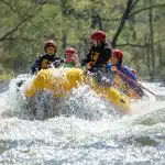 Smiling family having a blast white water rafting
