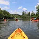 Kayaking through the Biltmore Estate central to Asheville North Caroline with a group. Kayakers enjoying one of the most scenic parts of the river that flows through AVL.