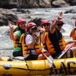 White water rafting on the French Broad River in Asheville, NC, wearing helmets and life jackets
