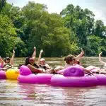 Group of people enjoying a tubing adventure on the French Broad River in Asheville