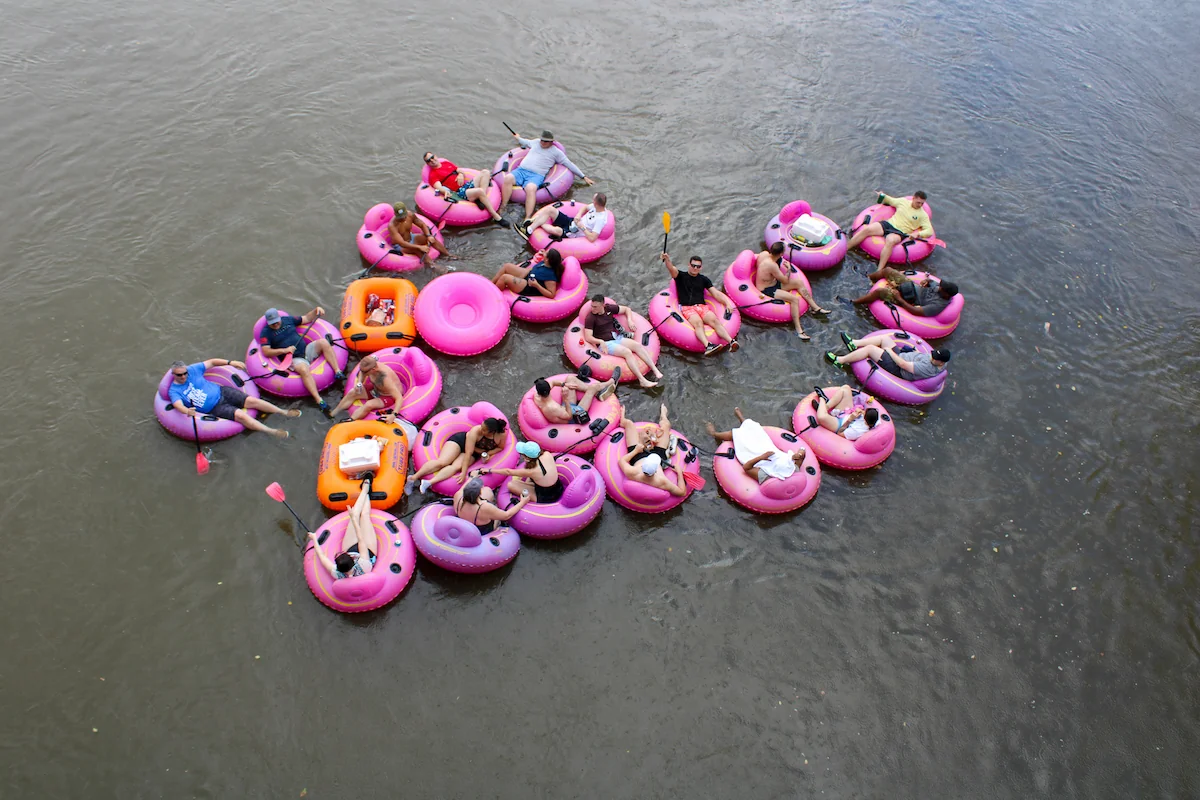 floating on pink inner tubes on the river